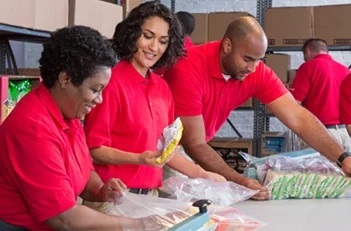A team in red shirts packing supplies.